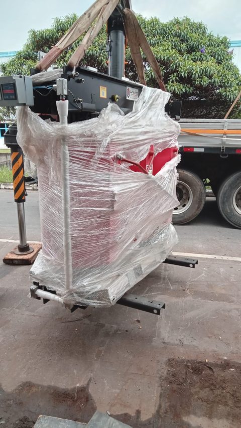 Máquina industrial embalada e içada por munck em serviço de relocação executado pela Maxtec